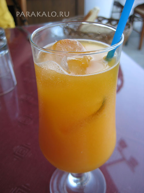 Бокал с апельсиновым соком и кусочками льда